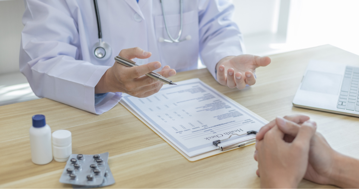 ICSR Narrative Writing Doctor discussing a health check form with a patient, with medication on the desk.